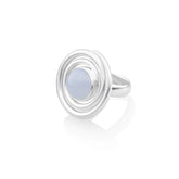 The Kaora Sandara Jewelry Silver Ring Open Spiral with Chalcedony (Size M) features a round, pale blue chalcedony centerpiece, encircled by open spiral sterling silver, shown on a white background.