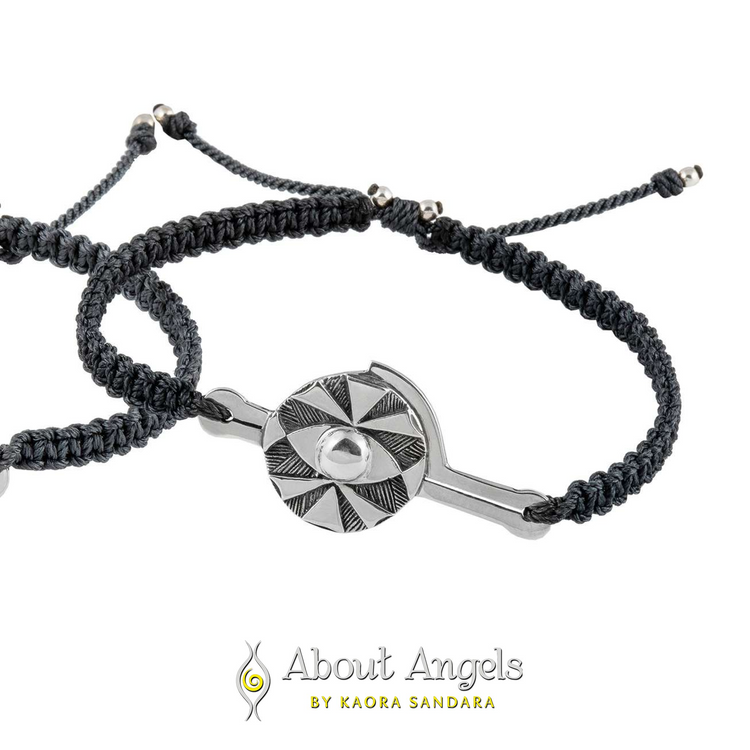 The Silver Male Bracelet on Black String with Code Protection by Kaora Sandara Jewelry features a sterling silver 925 geometric charm with a central clear stone for energy protection, shown on a white background with the brand logo and "About Angels by Kaora Sandara.