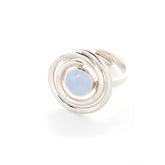 The Kaora Sandara Jewelry Silver Ring Open Spiral with Chalcedony, Size S, features a circular sterling silver design with concentric loops around a round pale blue chalcedony gemstone, shown on a white background.