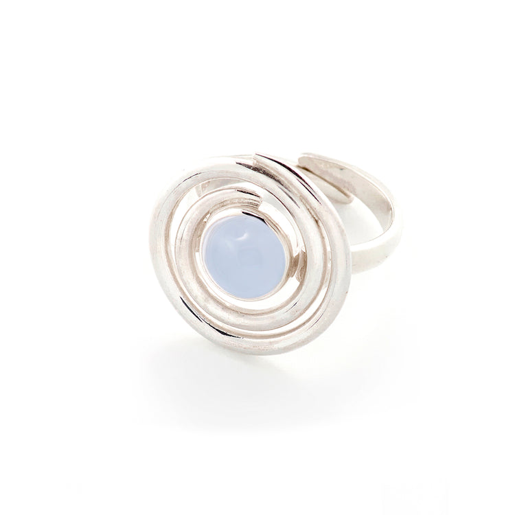 The Kaora Sandara Jewelry Silver Ring Open Spiral with Chalcedony, Size S, features a circular sterling silver design with concentric loops around a round pale blue chalcedony gemstone, shown on a white background.