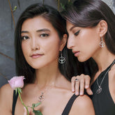 Two women pose together wearing Kaora Sandara Jewelry's "Releasing From the Deepest Fears" Earhooks in Sterling Silver with Black Agate (Size L); one holds a pink rose, both showcasing the elegant earhooks and necklaces.