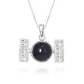 The Health Formula Pendant by Kaora Sandara Jewelry features sterling silver, a central round black agate, and two silver bars with three square crystals each, all on a fine chain and shown against a white background.