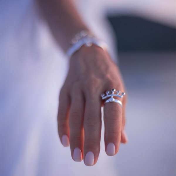 A close-up of a hand with light pink nails, wearing the Kaora Sandara Jewelry Silver Ring Wings with Crystal Sphere Gemstone, set against a softly blurred background.