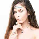 A woman with long brown hair wears Kaora Sandara Jewelry’s I'M A Queen Earhooks—Sterling Silver with Black Agate—showcasing striking, elegant earrings against a white background.