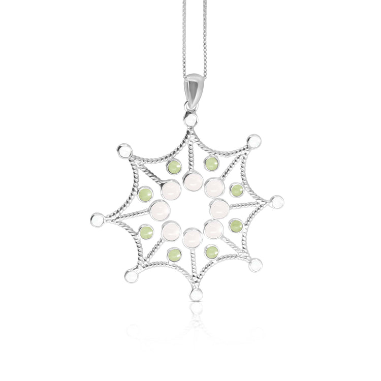The Freedom from the Ego Pendant by Kaora Sandara Jewelry features sterling silver shaped like a web, accented with rose quartz, peridot crystals, and hangs delicately from a chain against a white background.