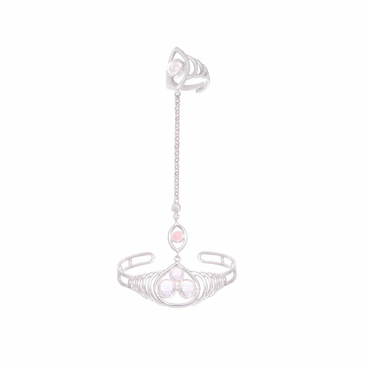 The Silver Hand Chain Transition Gift by Kaora Sandara Jewelry features a cuff bracelet and ring linked by a delicate chain, adorned with circular metalwork and crystal & rose quartz sphere gemstones, set against a white background.
