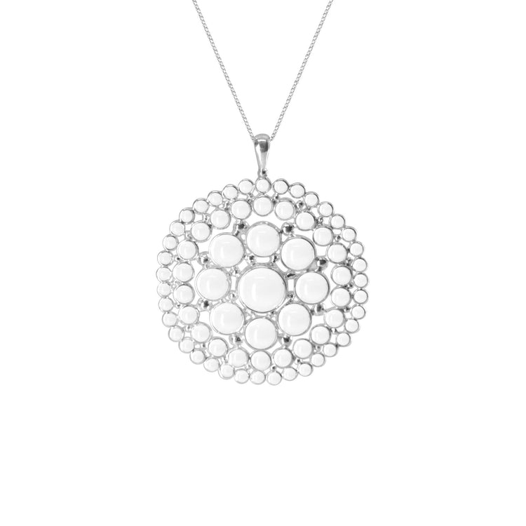 The Purity Pendant - Sterling Silver with Crystal, Size L by Kaora Sandara Jewelry features a round pendant with concentric raised white dots, creating a textured, symmetrical look on a thin chain.