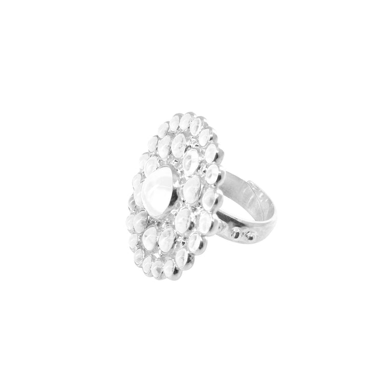 The Kaora Sandara Jewelry Purity Ring – Sterling Silver with Crystal (Size L) features a large flat round top with a central teardrop crystal, accented by small round stones in stylish concentric circles.